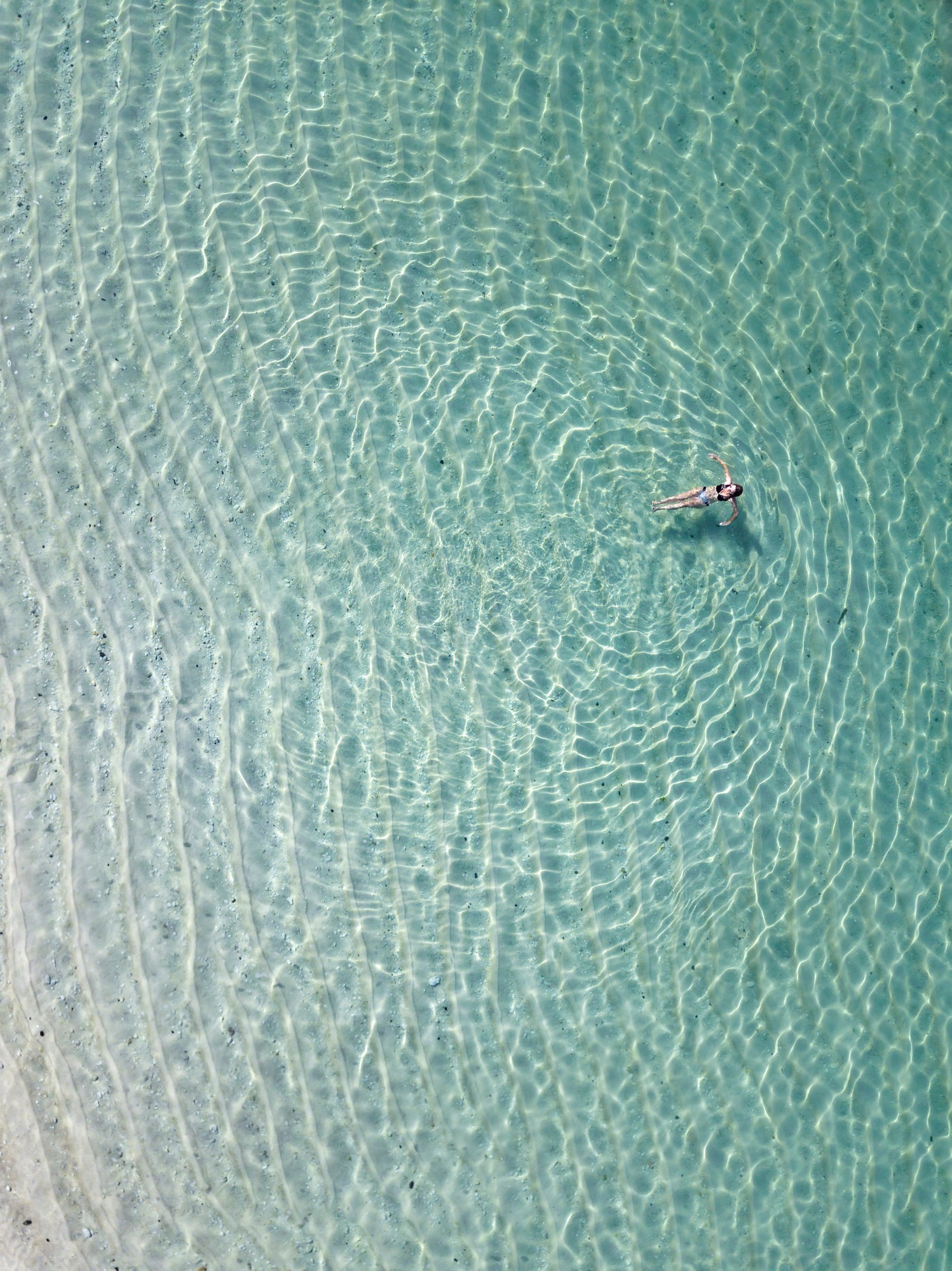 Indonesia, Bali, Melasti, Aerial view of Karma Kandara beach, woman in water